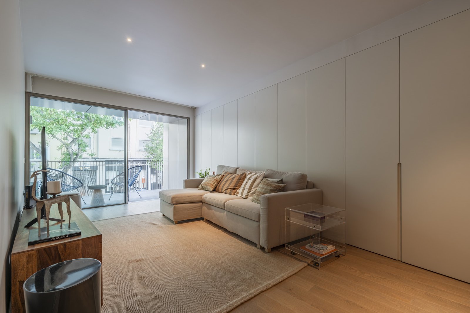 Sala com sofá e porta de vidro para a varanda